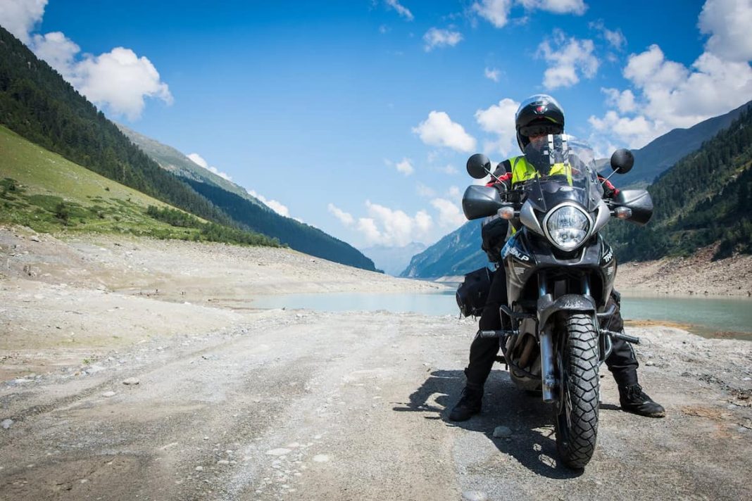 un motociclist calare pe o motocicleta pe un drum de munte